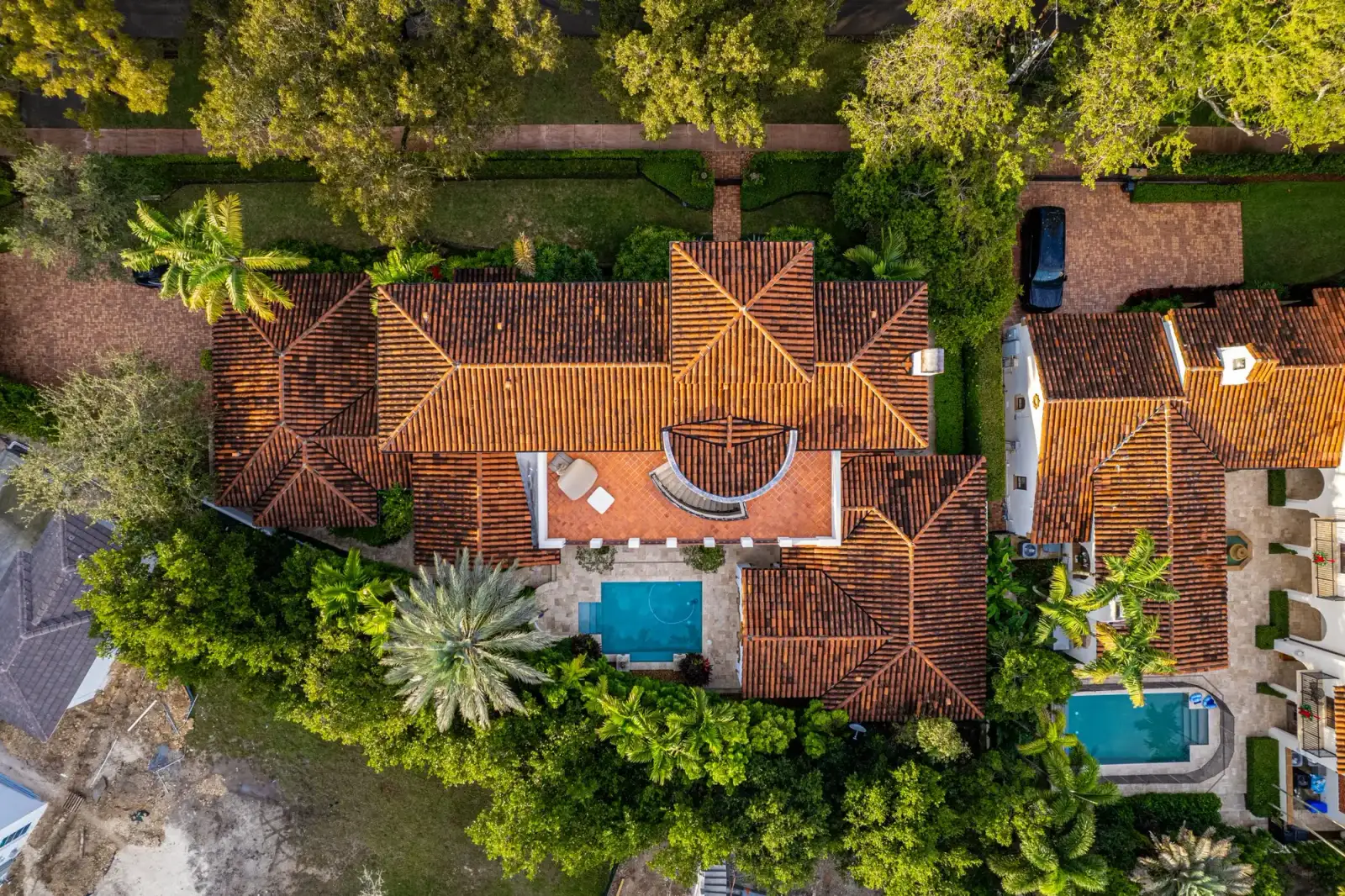 Aerial view of tile-roofed Florida homes with pools